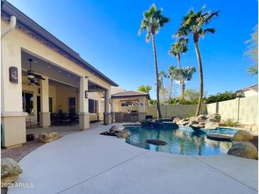 Inviting backyard with a sparkling pool, spa, and covered patio at 12762 W Vista Paseo Dr, Litchfield Park, AZ 85340