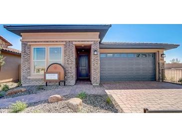 Craftsman style home with gray garage door and brick facade at 19417 W Badgett Ln, Litchfield Park, AZ 85340