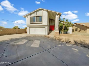 Two-story house with red door, attached garage, and landscaping at 2946 E Grove Cir, Mesa, AZ 85204