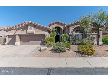 Beautiful desert landscaping surrounds this single-story home with a 3-car garage at 4410 E Robin Ln, Phoenix, AZ 85050