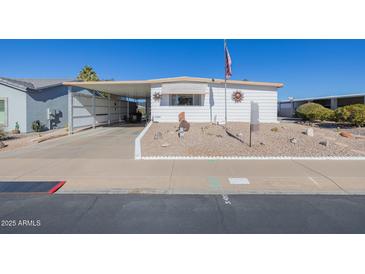 White single-wide manufactured home with carport and landscaped yard at 5646 E Player Pl, Mesa, AZ 85215