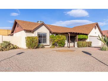 Single story home with attractive landscaping and a two-car garage at 6026 W Juniper Ave, Glendale, AZ 85306