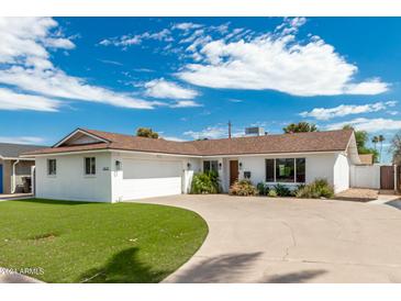 Beautiful ranch-style home with a well-manicured lawn and driveway at 8631 E Jackrabbit Rd, Scottsdale, AZ 85250