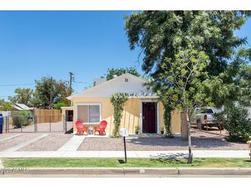 Cute yellow house with a red chair and nicely landscaped yard at 122 W Washington Ave, Gilbert, AZ 85233