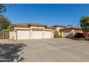 Three-car garage and desert landscaping highlight this beautiful home's exterior at 5128 W Pedro Ln, Laveen, AZ 85339