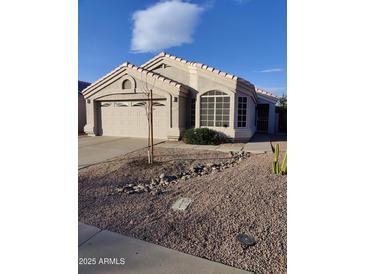 Single-story home with a two-car garage and nicely landscaped front yard at 1042 W Morelos St, Chandler, AZ 85224