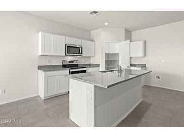 Modern kitchen with white cabinets, granite countertops, and island at 1402 W Hess Ave, Coolidge, AZ 85128