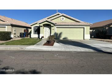 Light green one-story house with a two-car garage and well-maintained landscaping at 1434 E Detroit St, Chandler, AZ 85225