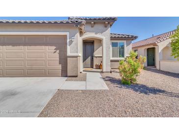 Charming home featuring a two-car garage, desert landscaping, and a welcoming front entrance at 19724 W Palo Verde Dr, Litchfield Park, AZ 85340