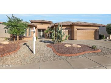 One-story house with desert landscaping, two-car garage, and neutral color scheme at 19939 N Golden Barrel Dr, Surprise, AZ 85374