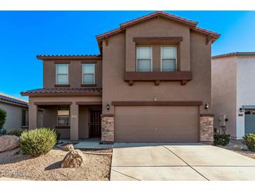 Two-story house with a brown exterior, two-car garage, and desert landscaping at 20673 N Marquez Dr, Maricopa, AZ 85138