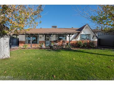 Charming ranch house with a spacious lawn and covered porch at 2649 N Granite Reef Rd, Scottsdale, AZ 85257