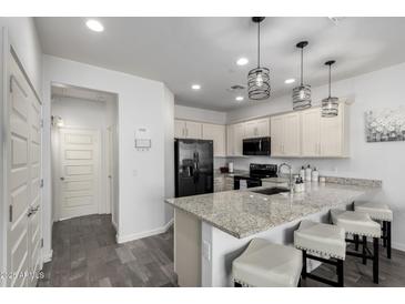 Modern kitchen features granite countertops, stainless steel appliances, and a breakfast bar with seating at 4058 E Erie E St # 103, Gilbert, AZ 85295