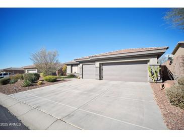 House exterior features a three-car garage and desert landscaping at 42028 N Crooked Stick Rd, Anthem, AZ 85086