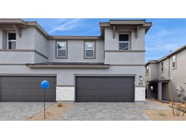 Modern two-story home featuring a gray exterior, two-car garage, and well-manicured landscaping at 5819 E Rose Garden Ln, Phoenix, AZ 85054