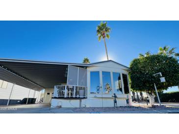 Inviting manufactured home exterior, featuring a covered patio and mature landscaping at 8700 E University Dr # 633, Mesa, AZ 85207