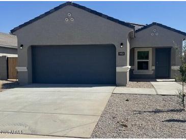 Charming single-story home with neutral gray exterior, a two-car garage, and well-maintained landscaping at 1413 W Hess Ave, Coolidge, AZ 85128