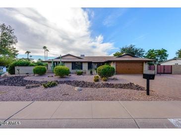 Single-story home with desert landscaping and a two-car garage at 5345 E Evans Dr, Scottsdale, AZ 85254