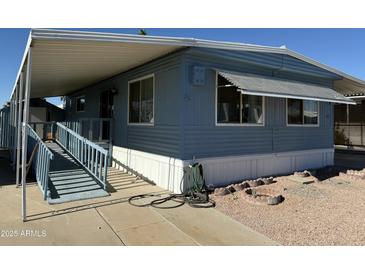 Mobile home with carport, ramp, and landscaped yard at 9501 E Broadway Rd # 107, Mesa, AZ 85208