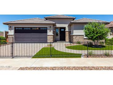 Single-story home with a two-car garage and landscaped front yard at 1176 E Ridgerock St, Casa Grande, AZ 85122