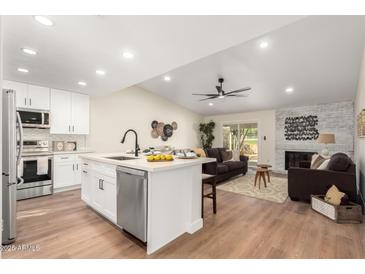 Remodeled kitchen with island, stainless steel appliances, and white shaker cabinets at 11808 S Half Moon Dr, Phoenix, AZ 85044