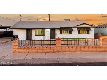 Charming single-story home with a well-manicured lawn and brick fence at 132 W Beautiful Ln, Phoenix, AZ 85041