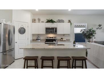 Modern kitchen with white cabinets, granite island, and stainless steel appliances at 25587 N Boreas Rd, Florence, AZ 85132