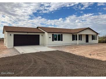 New single-story home with attached garage, neutral exterior, and desert landscaping at 25603 W Hedgehog Rd, Wittmann, AZ 85361