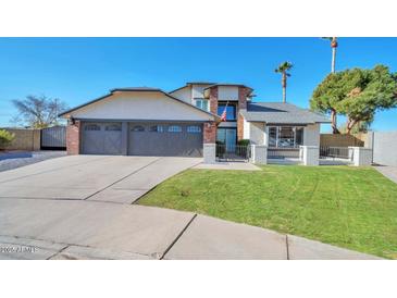 Two-story home with three-car garage and landscaped lawn at 4818 E Dartmouth Cir, Mesa, AZ 85205