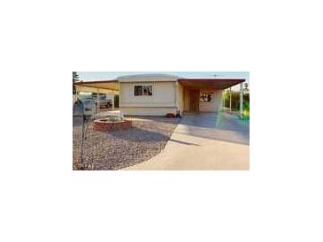 Mobile home exterior with carport and gravel driveway at 8627 E Dulciana Ave # 43, Mesa, AZ 85208