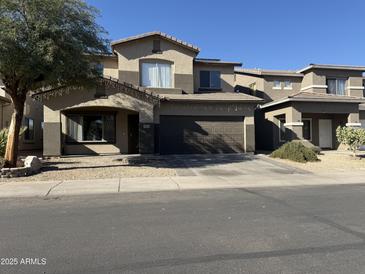 Two-story house with a brown garage door and a landscaped front yard at 9420 S 35Th Gln, Laveen, AZ 85339