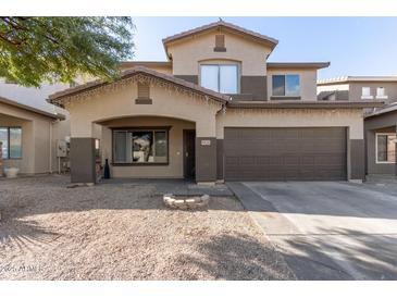 Two-story house with a brown garage door and landscaping at 9420 S 35Th Gln, Laveen, AZ 85339