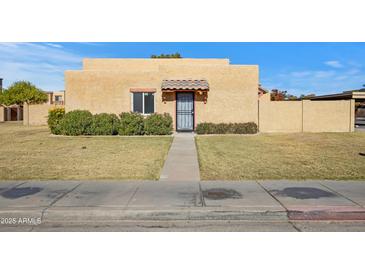 Tan stucco house with a tiled entryway and well-manicured lawn at 948 S Alma School Rd Rd # 89, Mesa, AZ 85210