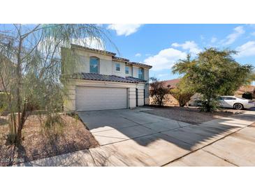 Two-story house with a beige exterior, two-car garage, and landscaping at 219 E Beth Dr, Phoenix, AZ 85042