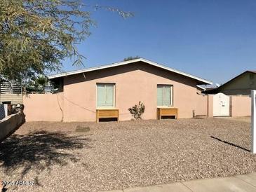 Tan single story home with gravel yard and gated entry at 2348 W Laurel Ln, Phoenix, AZ 85029