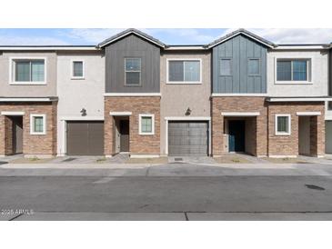 Three-unit townhome building with attached garages and neutral color palette at 2822 W White Feather Ln, Phoenix, AZ 85085