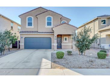 Two-story house with gray garage door and landscaping at 36085 W Prado St, Maricopa, AZ 85138