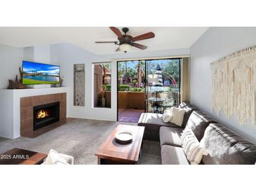 Cozy living room featuring a fireplace and sliding glass door leading to a patio at 5122 E Shea Blvd # 1100, Scottsdale, AZ 85254