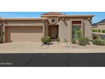 Tan stucco house with a two-car garage and nicely landscaped yard at 6318 N 19Th St, Phoenix, AZ 85016