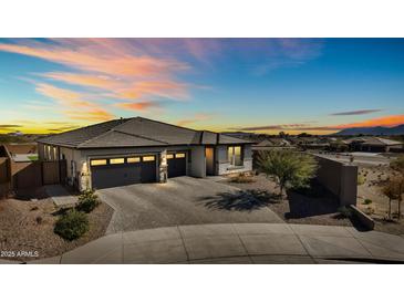 Single-story home with two-car garage, brick driveway, and landscaping at 6551 N 127Th Dr, Glendale, AZ 85307