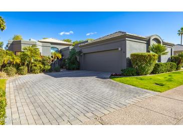 Exterior of a luxury home with a large driveway and lush landscaping at 7878 E Gainey Ranch Rd # 3, Scottsdale, AZ 85258