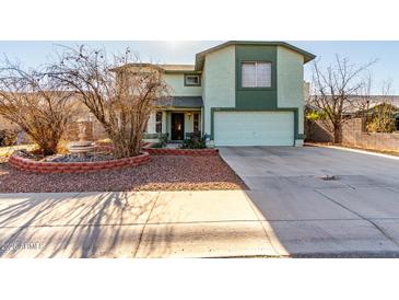 Two-story house with a green facade, attached garage, and a landscaped front yard at 8631 W Monte Vista Rd, Phoenix, AZ 85037