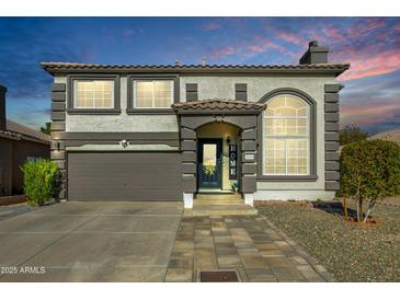 Two-story house with neutral color scheme and landscaped yard at 11020 W Lane Ave, Glendale, AZ 85307