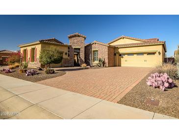 Single-story home with brick driveway and desert landscaping at 17730 W Redwood Ln, Goodyear, AZ 85338