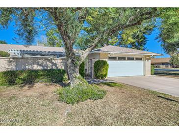 Single-story home with attached garage and mature landscaping at 18852 N Aztec Dr, Sun City, AZ 85373