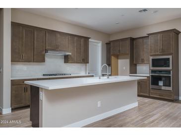 Modern kitchen with island, stainless steel appliances, and ample cabinetry at 2732 N 217Th Ave, Buckeye, AZ 85396