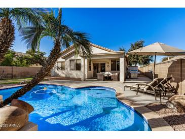 Inviting backyard oasis featuring a sparkling pool, patio furniture, and lush landscaping at 4795 E Bellerive Dr, Chandler, AZ 85249