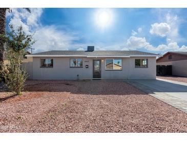 Newly renovated single story home with gray exterior and a landscaped front yard at 5927 W Mulberry Dr, Phoenix, AZ 85033