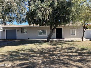 Cute ranch home with a landscaped lawn and attached garage at 7015 N 23Rd Ln, Phoenix, AZ 85021