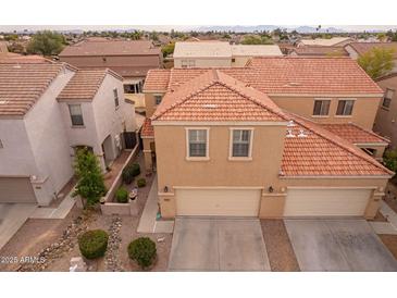 Two-story house with tile roof, two-car garage, and landscaped yard at 7019 W Mcmahon Way, Peoria, AZ 85345